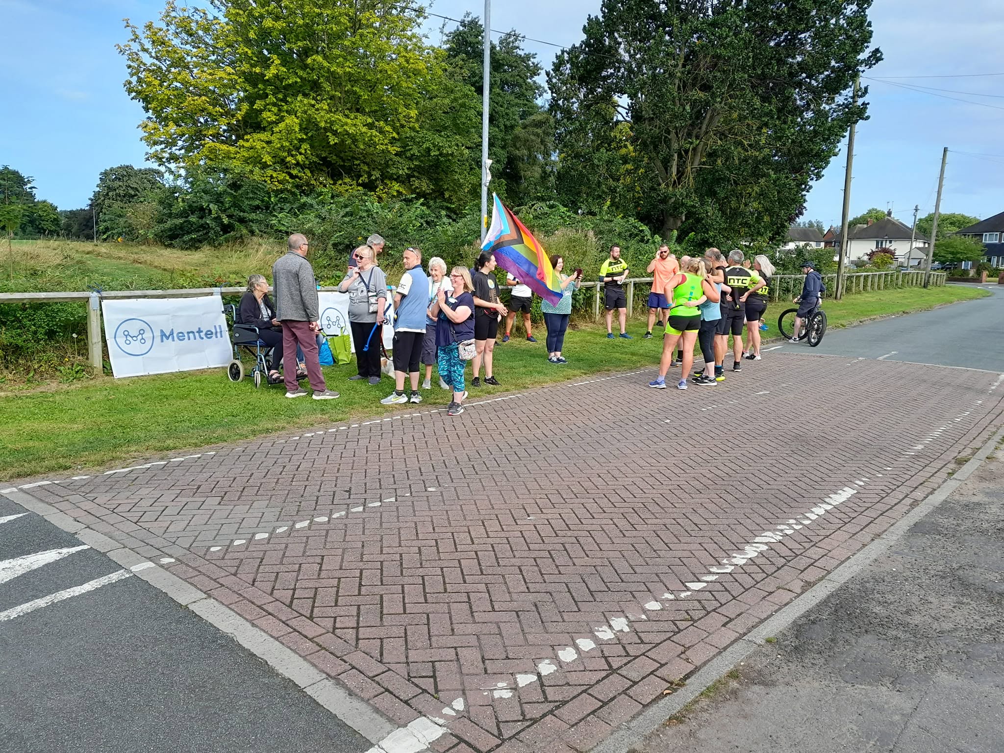 Volunteers and participants meeting near the start area with a rainbow flag