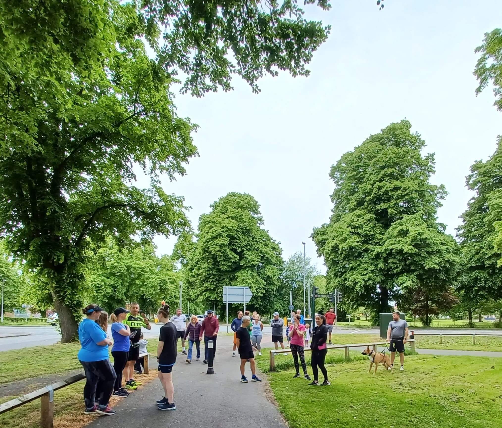 People arriving and gathering in the park before the start